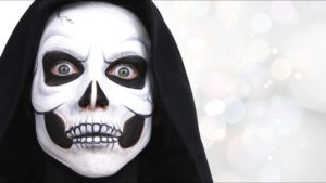 Un maquillage d'Halloween effrayant sous la forme d'un crâne squelette est réalisé avec des nuances de noir et de blanc, accentuant les détails sinistres.