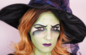 Une femme mystérieuse vêtue en sorcière avec un maquillage envoûtant, prête à jeter des sorts lors de la soirée d'Halloween