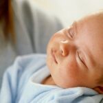 Maman relaxant son bébé avant le coucher avec une routine apaisante.