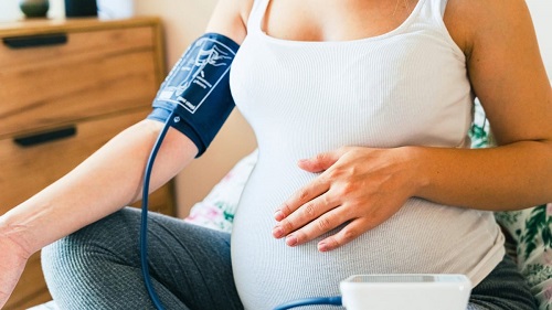 Illustration représentant une femme enceinte vérifiant sa pression artérielle pour la gestion de l'hypertension pendant la grossesse.